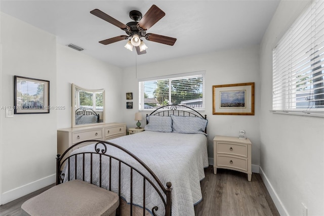 bedroom featuring visible vents, baseboards, wood finished floors, and a ceiling fan