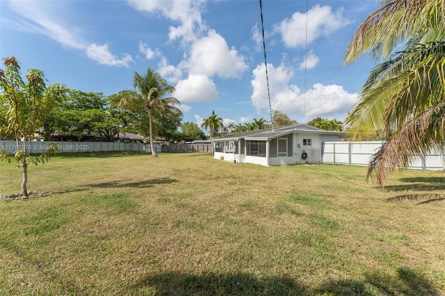 view of yard with a fenced backyard and a sunroom