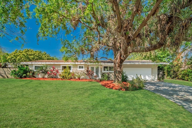 ranch-style house featuring a front yard, an attached garage, and concrete driveway