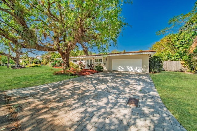 ranch-style house with a front lawn, fence, stucco siding, driveway, and an attached garage