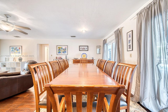 dining room featuring ceiling fan, visible vents, and wood finished floors