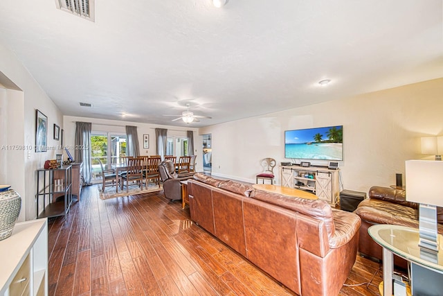 living area featuring hardwood / wood-style flooring, visible vents, and ceiling fan