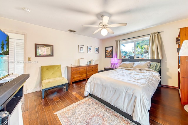 bedroom featuring visible vents, baseboards, a ceiling fan, and hardwood / wood-style flooring