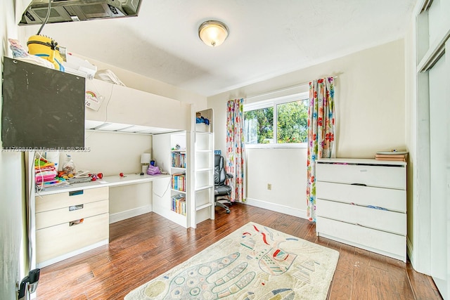 bedroom with a closet, baseboards, and wood finished floors