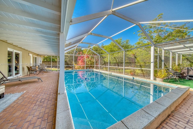 outdoor pool with a patio area and glass enclosure