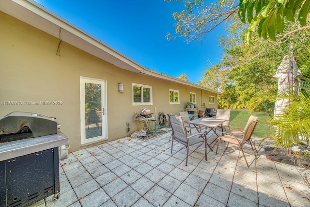 view of patio / terrace with outdoor dining area, central air condition unit, and a grill