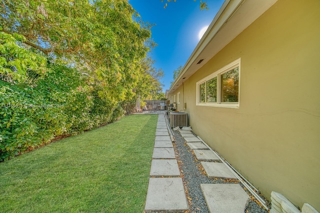 view of yard featuring central AC unit and fence