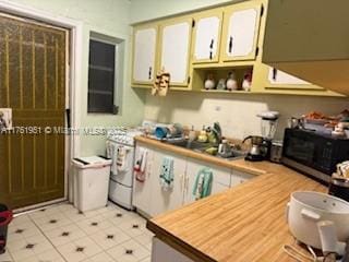 kitchen with open shelves, gas stove, light countertops, and a sink