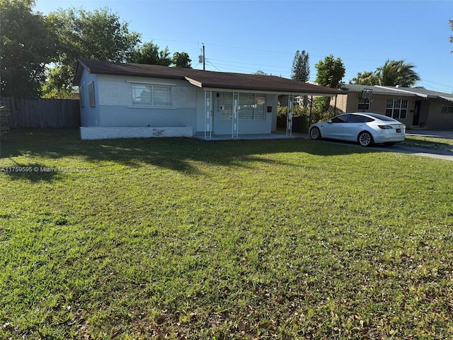 single story home featuring a carport, stucco siding, a front yard, and fence