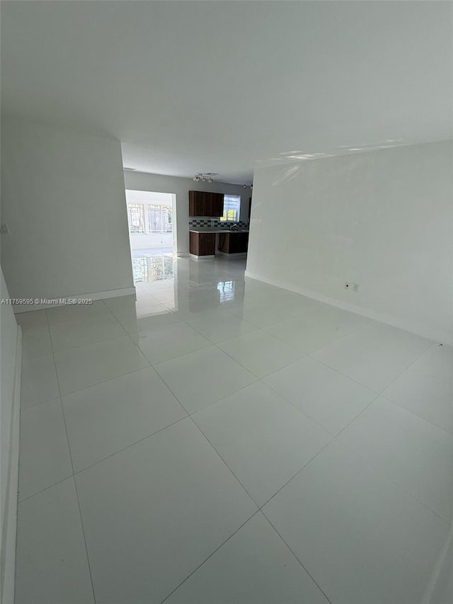 empty room with light tile patterned floors and baseboards