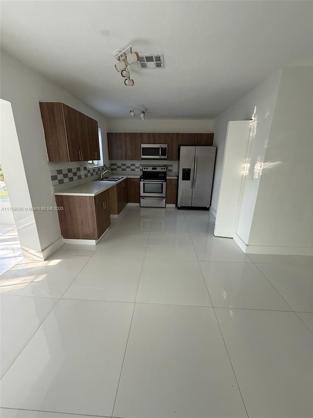 kitchen featuring visible vents, a sink, light countertops, appliances with stainless steel finishes, and backsplash