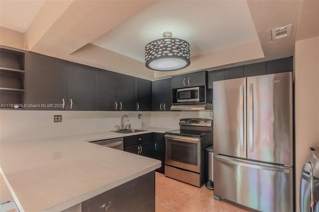 kitchen with visible vents, a sink, stainless steel appliances, a peninsula, and light countertops