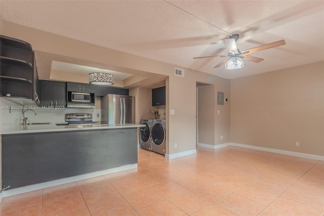 kitchen featuring washer and clothes dryer, a sink, open shelves, stainless steel appliances, and light tile patterned flooring