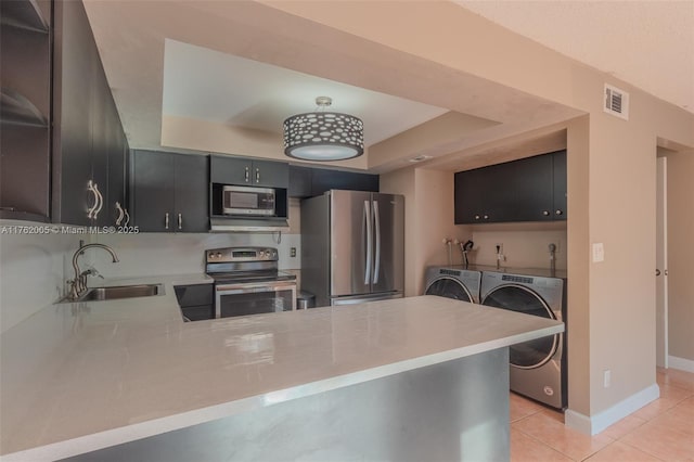 kitchen with visible vents, a sink, light countertops, appliances with stainless steel finishes, and washer and dryer