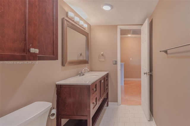 half bath featuring visible vents, toilet, tile patterned flooring, baseboards, and vanity