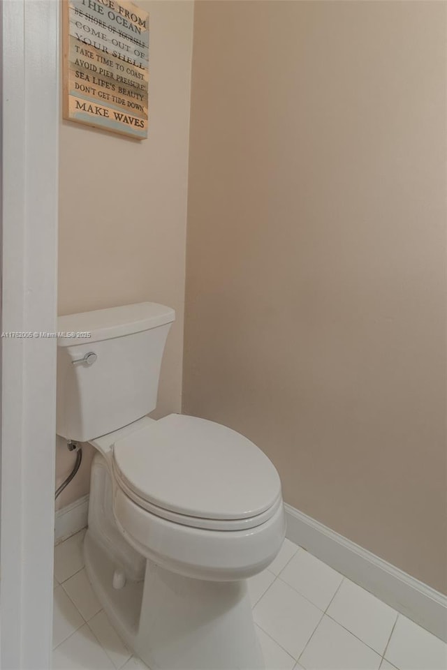 bathroom featuring tile patterned flooring, toilet, and baseboards