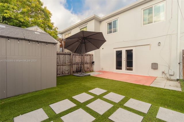 back of house featuring fence, stucco siding, a lawn, french doors, and a patio