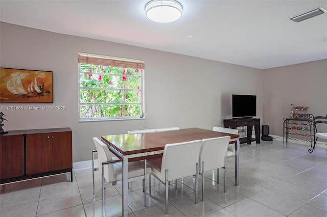 dining room featuring light tile patterned floors, visible vents, and baseboards