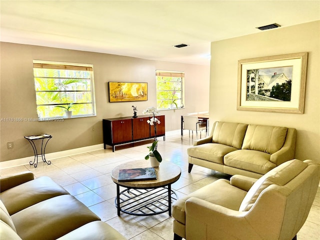 living area with light tile patterned flooring, visible vents, and baseboards