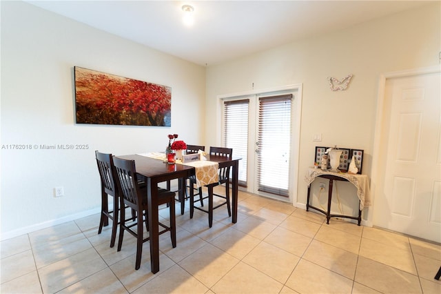 dining room featuring baseboards and light tile patterned flooring