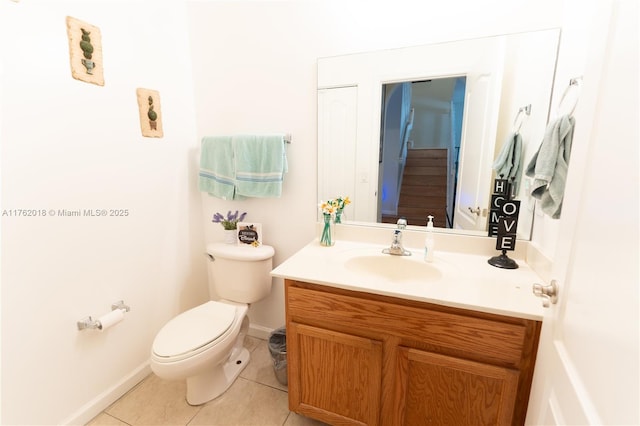 bathroom featuring baseboards, toilet, vanity, and tile patterned flooring