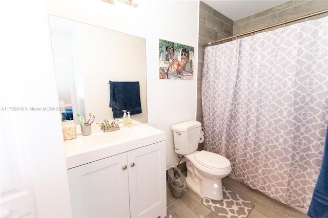 full bathroom with curtained shower, toilet, vanity, and wood finished floors