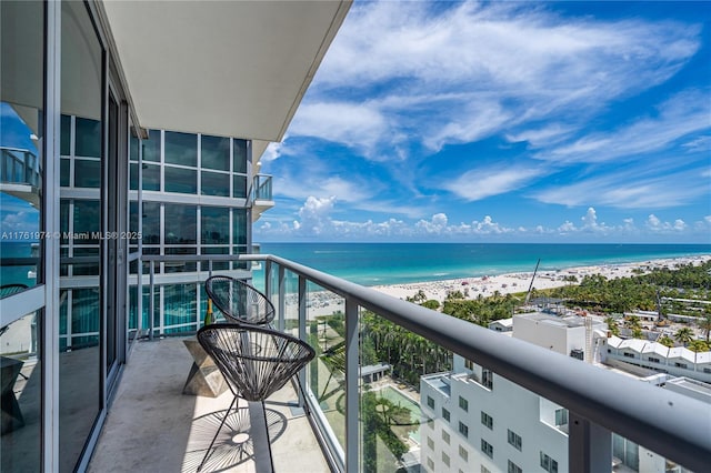 balcony featuring a beach view and a water view