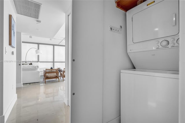 clothes washing area with visible vents, marble finish floor, stacked washer and clothes dryer, and laundry area