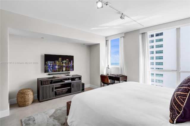 bedroom with rail lighting and baseboards