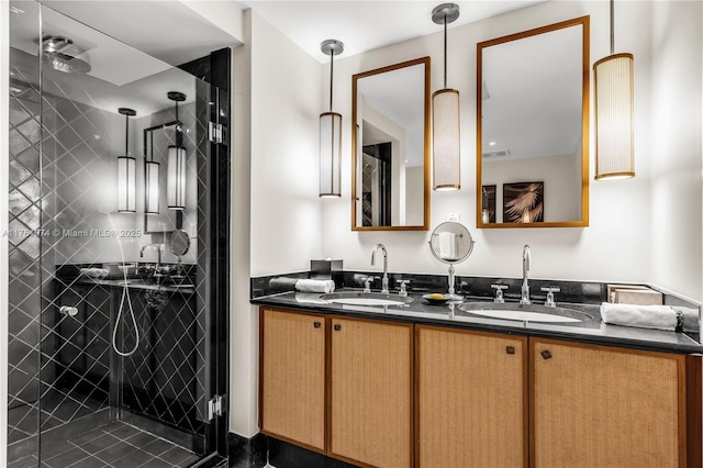 full bathroom featuring double vanity, a stall shower, and a sink