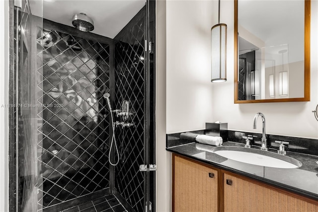 full bath featuring a tile shower and vanity