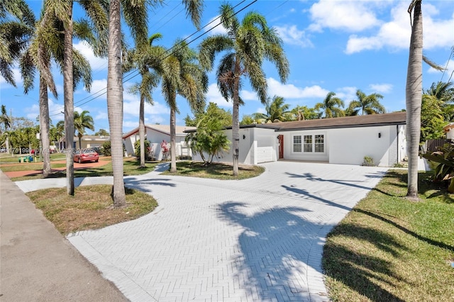 view of front of house with stucco siding and decorative driveway