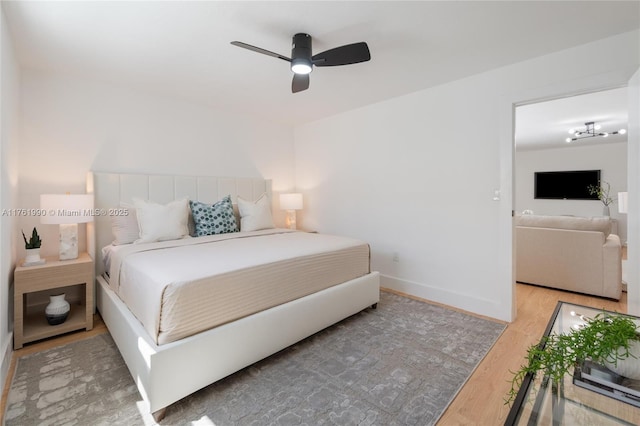 bedroom with a ceiling fan, baseboards, and wood finished floors