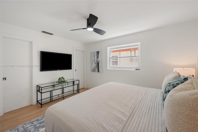 bedroom with visible vents, light wood-style floors, and ceiling fan