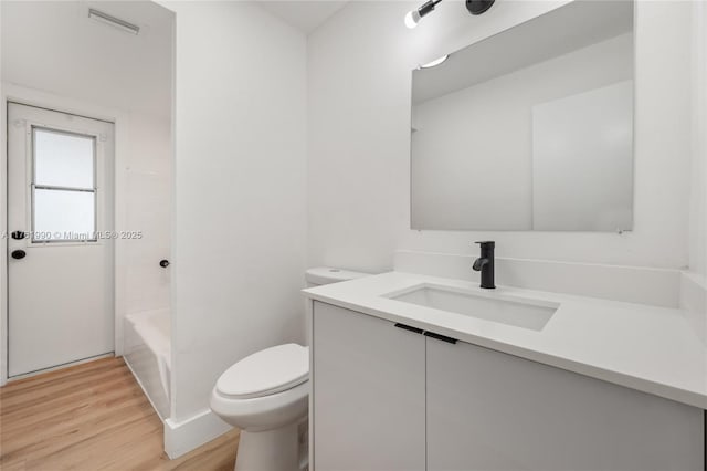 full bathroom featuring visible vents, toilet, wood finished floors, and vanity