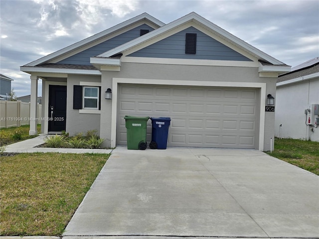 view of front of property featuring stucco siding, a front lawn, a garage, and driveway