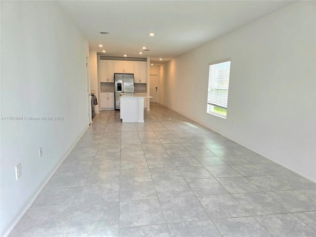 unfurnished living room with light tile patterned flooring, visible vents, recessed lighting, and baseboards