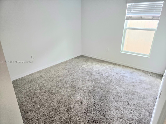 unfurnished room with baseboards and carpet