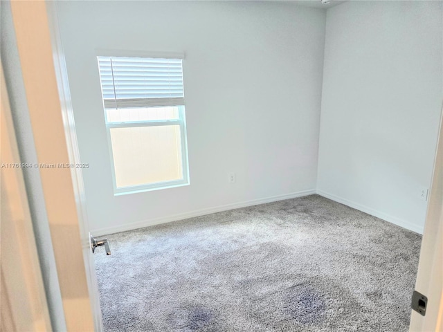 empty room with baseboards and carpet