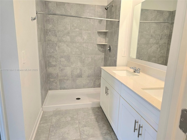 bathroom with a shower stall, double vanity, and a sink