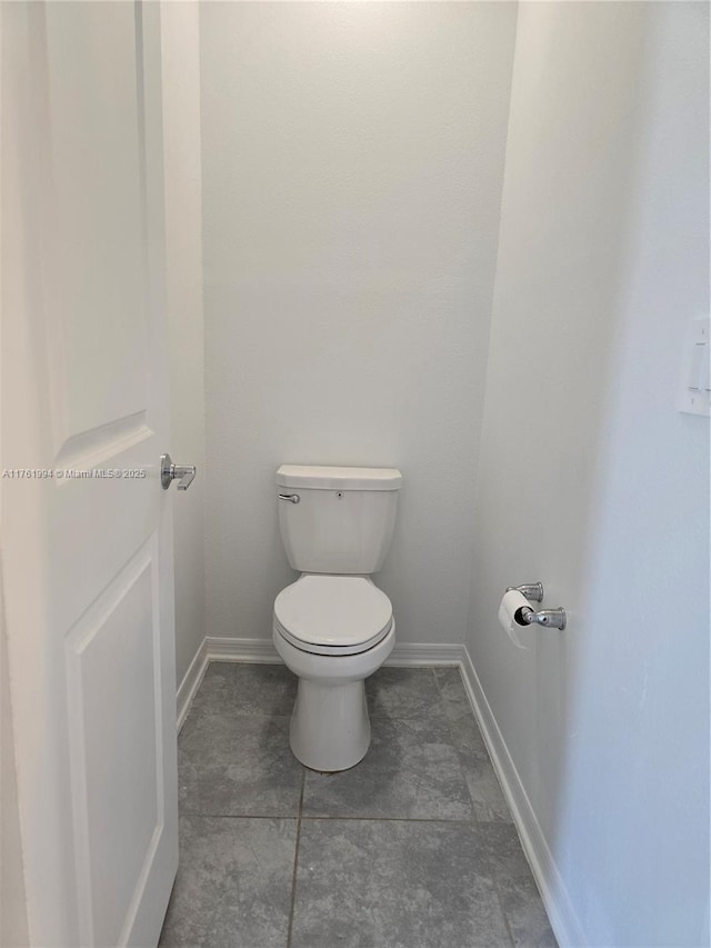 bathroom featuring toilet and baseboards