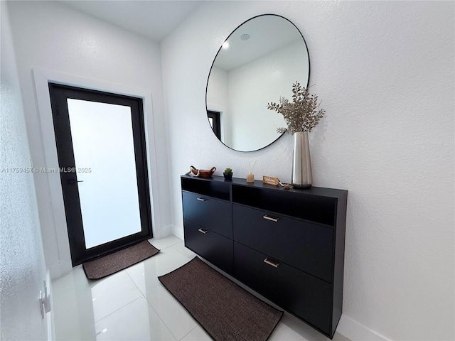 bathroom featuring tile patterned floors, vanity, and a textured wall