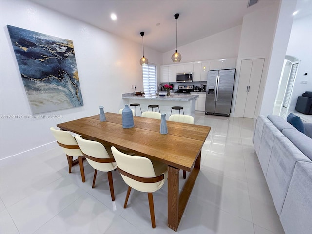 dining space featuring arched walkways, recessed lighting, high vaulted ceiling, and light tile patterned flooring