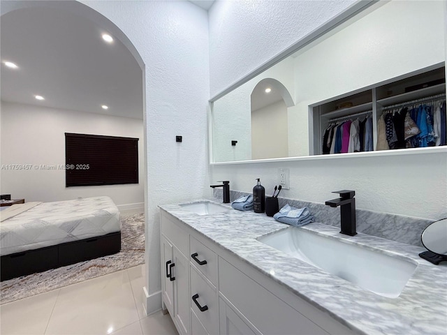 bathroom with double vanity, tile patterned floors, ensuite bathroom, and a sink