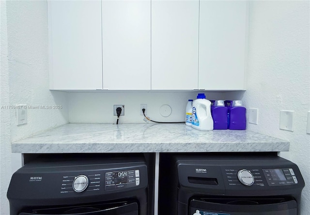 interior details with washing machine and clothes dryer and a textured wall