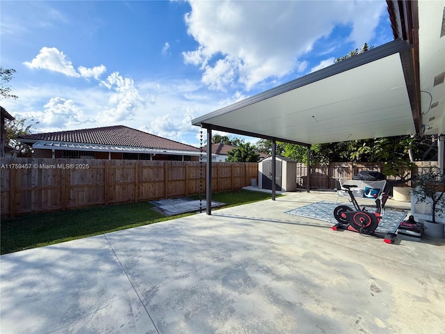 view of patio featuring an outdoor structure, a fenced backyard, and a shed