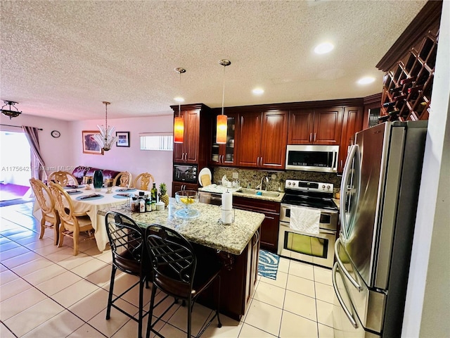 kitchen featuring a healthy amount of sunlight, tasteful backsplash, stainless steel appliances, and light tile patterned floors