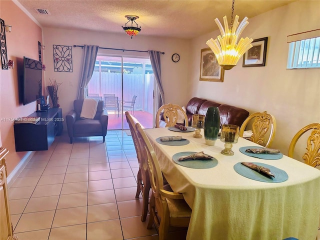 tiled dining area with a textured ceiling, visible vents, a wealth of natural light, and a notable chandelier