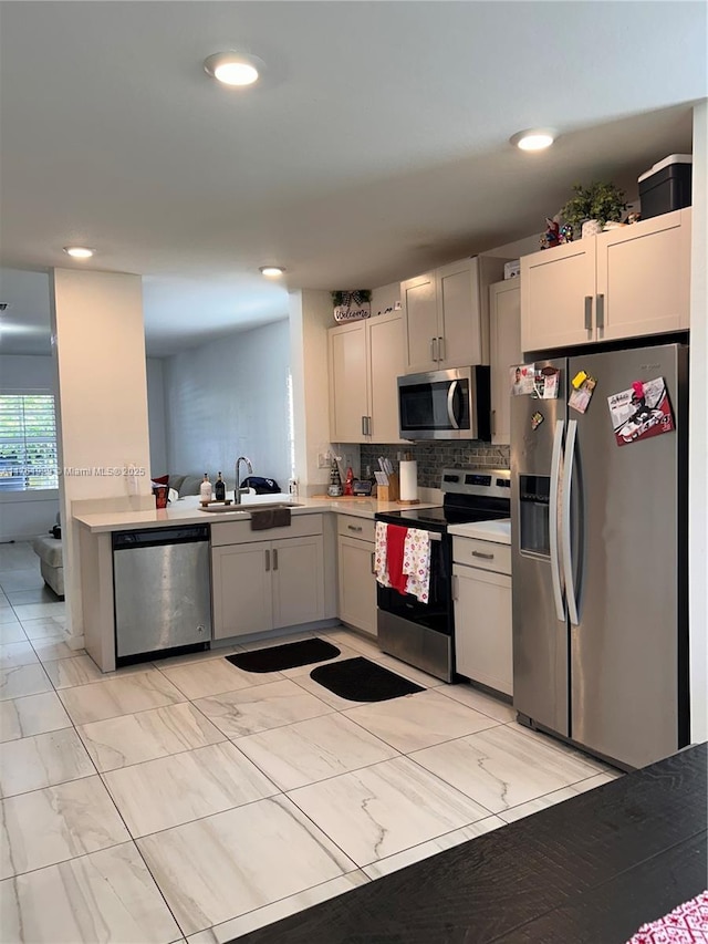 kitchen featuring a sink, light countertops, appliances with stainless steel finishes, marble finish floor, and backsplash