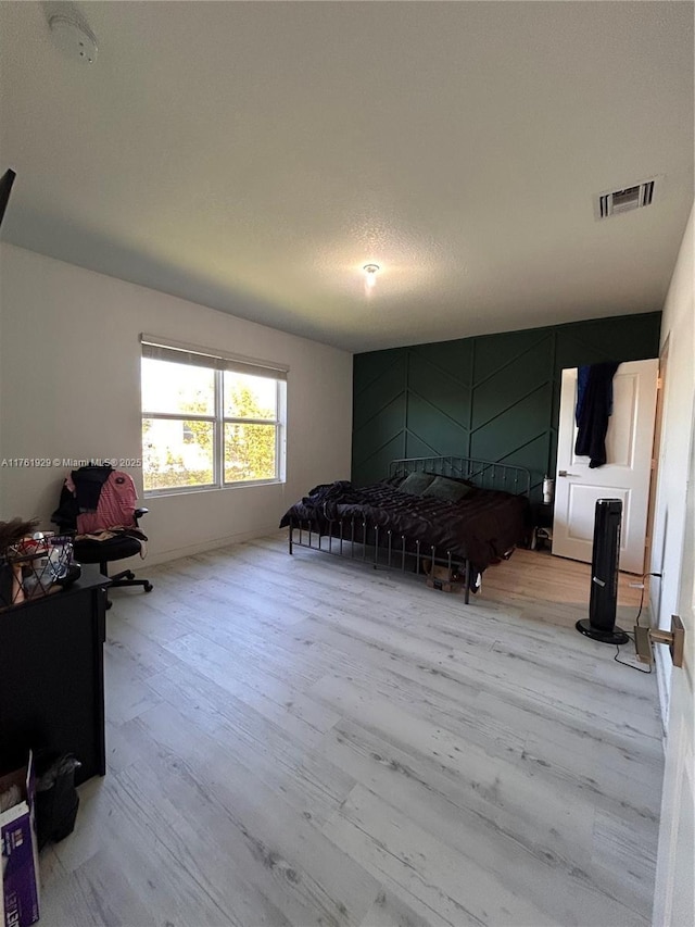 bedroom with visible vents and wood finished floors